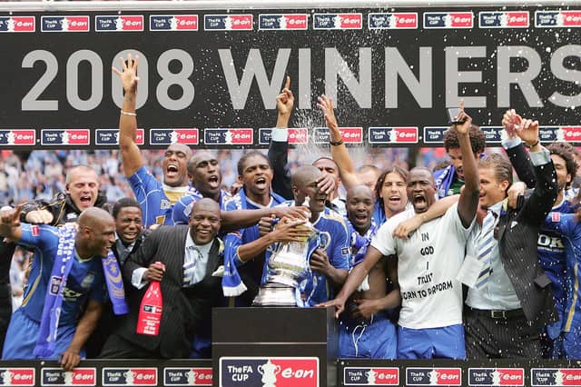 The Portsmouth team celebrate with the FA Cup trophy after their FA Cup final match against Cardiff City at Wembley football Stadium, London on May 17, 2008. Portsmouth won the match 1-0. AFP PHOTO / CARL DE SOUZA (Photo credit should read CARL DE SOUZA/AFP via Getty Images)