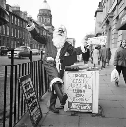 An Evening News vendor gets into the Christmas spirit by dressing as Santa Claus at his pitch outside Frasers department store in Princes Street Edinburgh, December 1986.