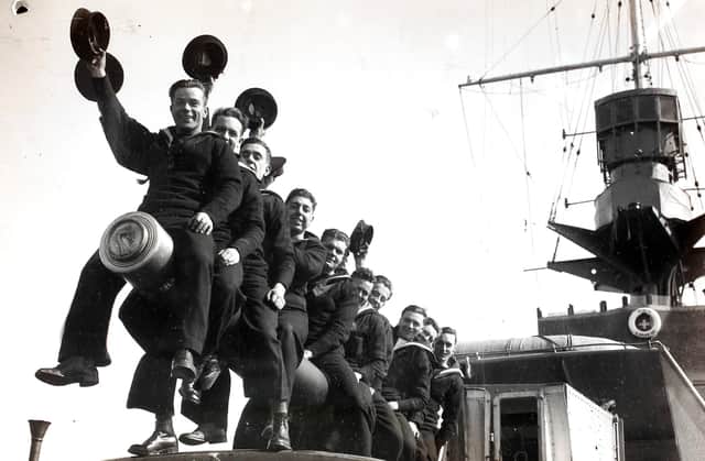 A group of RNVR (Royal Naval Volunteer Reserve) ratings raise a cheer on reaching Plymouth, England on the 'HMS Curacoa'. Officers and ratings of the RNVR (London and Sussex Divisions) are spending Easter afloat - they left Portsmouth for Plymouth and Torbay and are carrying out practical training including gunnery during their cruise. (Photo by Fox Photos/Hulton Archive/Getty Images)