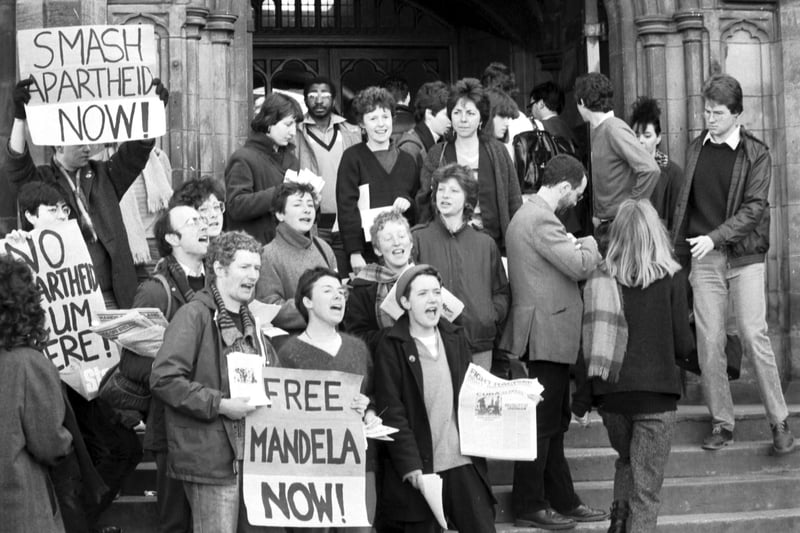 Demonstrators from Edinburgh University's Anti-Aparttheid society protesting outside Teviot Row House in March 1984. One student holds a Free Mandela Now placard.