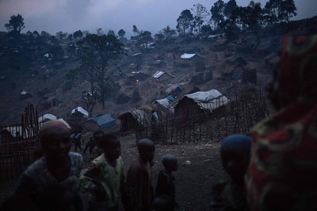 Displaced persons from the Bafuliru community stand amidst the makeshift shelters of the internally displaced persons (IDP) camp of Bijombo, South Kivu Province, eastern Democratic Republic of Congo.