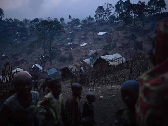 Displaced persons from the Bafuliru community stand amidst the makeshift shelters of the internally displaced persons (IDP) camp of Bijombo, South Kivu Province, eastern Democratic Republic of Congo.