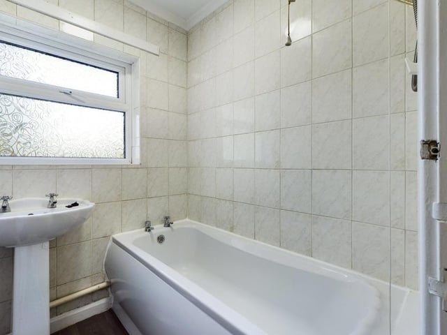 Family Bathroom - Pannelled bath with electric shower unit over and pedestal wash basin; uPVC double glazed window to the side elevation, tiled walls, extractor fan and radiator panel.