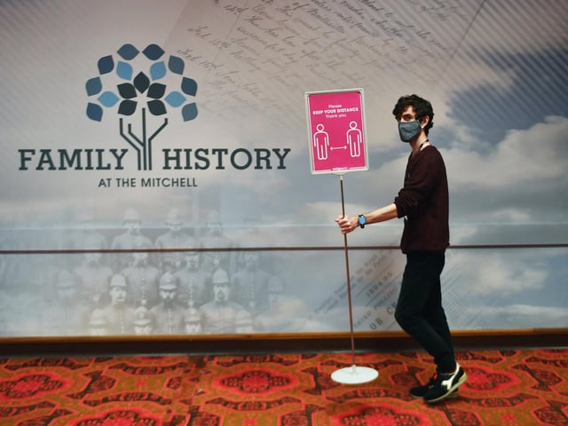 Michael Gallacher, archivist places a sign at the Mitchell.