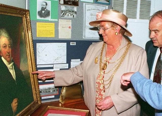 At a reunion in 1997 - ex-pupils look upon a painting of the founder of the trust Rev William Car Fenton.