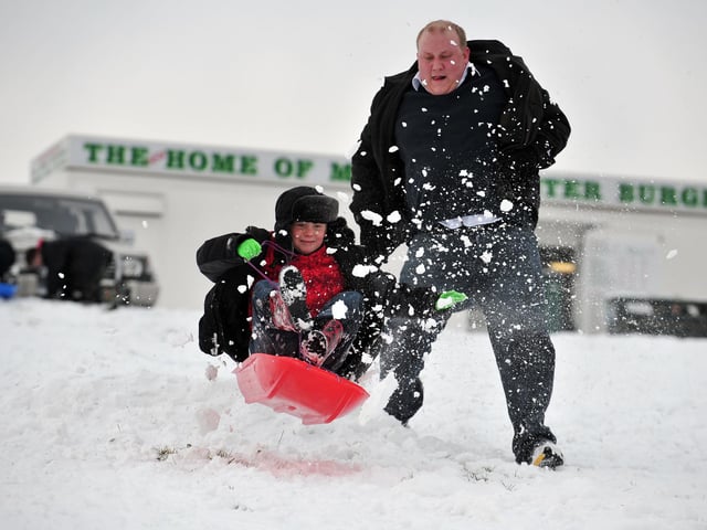 Mike Wright and his son Toryn Willis sledging off a ramp they made in the snow on top of Portsdown Hill.