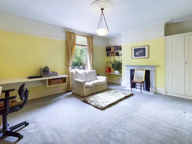 Bedroom - Currently in use a first floor lounge - Single glazed timber framed window to the front elevation, ceiling coving, picture rail, period fire surround with raised hearth and cast iron inset, fitted cupboard to the chimney breast recess and fitted desk.