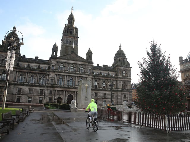 A cyclist makes his through a quiet George Square in Glasgow.