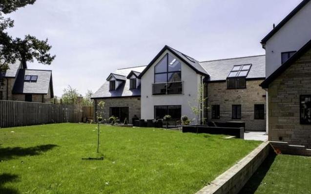 The property is surrounded by landscaped gardens to all sides, with the front garden laid to lawn, an expansive rear garden of split level, a granite patio, and children garden area laid to Astro turf.