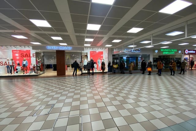 Shoppers queuing in Middleton Grange Shopping Centre.