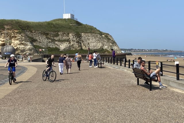 A young pair cycle along the seafront as temperatures soar in Sunderland