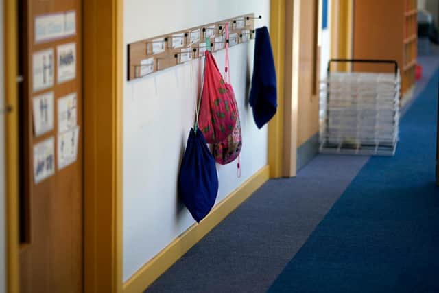 Children's PE bags hang on coat hooks at a primary school (Photo by Christopher Furlong/Getty Images)