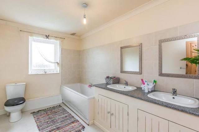 The main bathroom is attractive, fitted with a suite that comprises a panelled bath, low-level WC and double-sink unit. The walls are part-tiled, while there is an obscured window to the back.