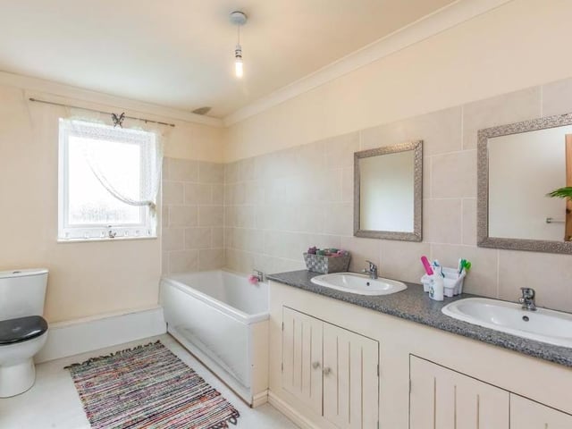 The main bathroom is attractive, fitted with a suite that comprises a panelled bath, low-level WC and double-sink unit. The walls are part-tiled, while there is an obscured window to the back.