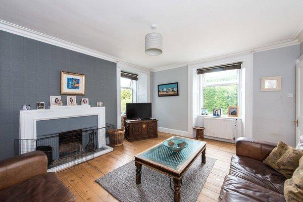 The living room boasts modern styling and an open fire