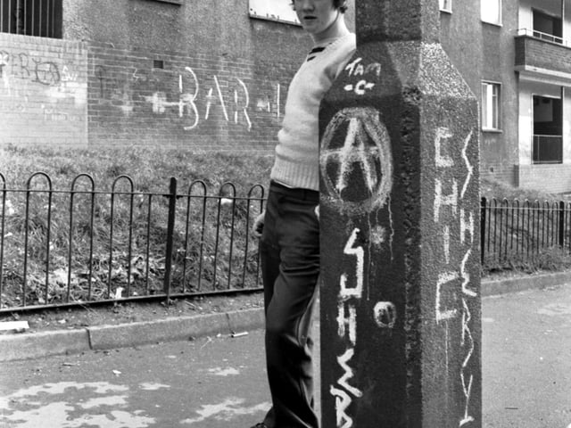 Run-down, neglected and covered in graffiti, the flats at Pendeen Crescent (known as Scotland's Street of Shame) in Glasgow, November 1980. Boy is unidentified.