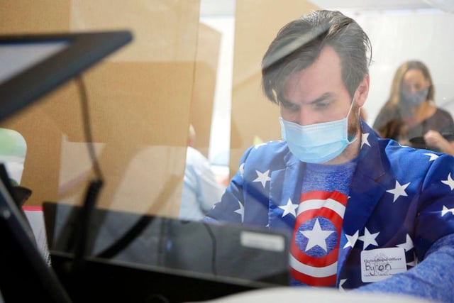 Poll worker Byron Rae works behind protective plexiglass on Election Day at downtown Summerlin in Las Vegas, Nevada.