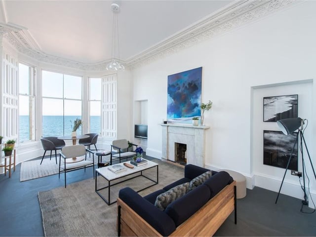 The bright living room has bay windows and a fireplace.