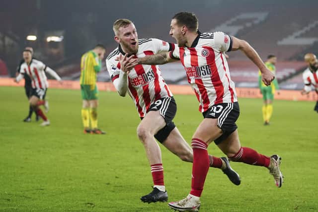 Sheffield United's Oliver McBurnie, left, runs to hug teammate Billy Sharp, right, who scored his side's second goal during the English Premier League match between Sheffield United and West Bromwich Albion at Bramall Lane . (AP Photo/Dave Thompson, Pool)