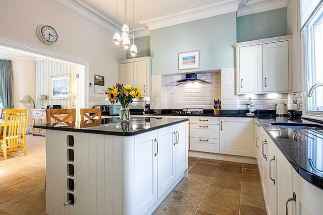The kitchen has a range of shaker-style units with granite worktops and integrated appliances which include a fridge freezer, electric oven, microwave combi-oven, plate warming drawer, a gas hob, and a dishwasher.