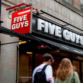 A pedestrian passes a Five Guys hamburger restaurant (Photo credit should read TOLGA AKMEN/AFP via Getty Images)
