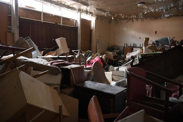 A huge pile of broken and unwanted furniture fills one of the rooms