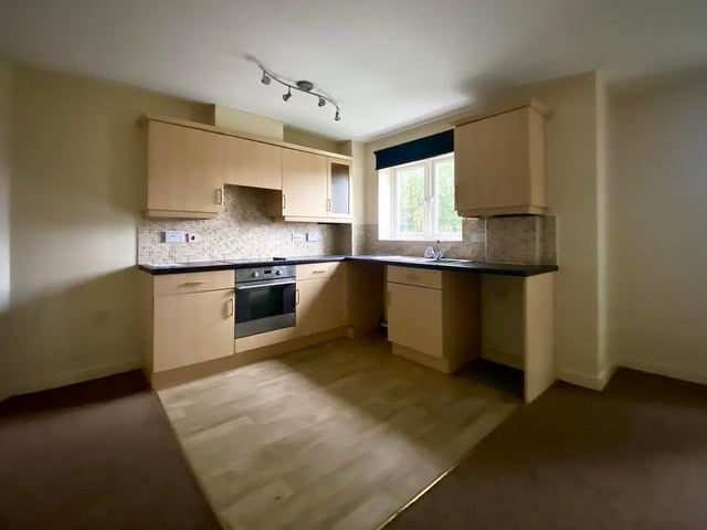 The kitchen area is compact, but boasts a range of high-level and low-level cupboards with worktops over, a sink basin with mixer taps and a linoleum floor. There is a window to the side of the flat.