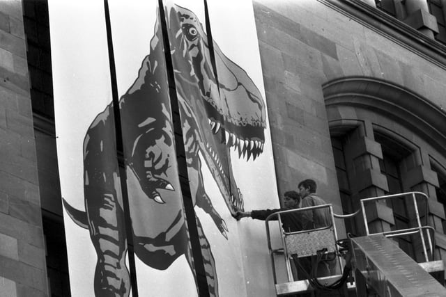 Workmen put up a giant Tyrannosaurus Rex poster outside the City Art Centre in Edinburgh to publicise the Dinosaurs Alive! exhibition in February 1990.