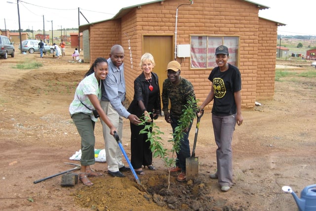 Maxwell A. Ayamba (second from right) of Sheffield Black and Ethnic Minority Environmental Network (SHEBEEN) South Africa in 2009 on  a British Council Leadership Programme planting a tree with the Mayor of Cosmo City Extension 4 (middle in black) and two South African British Council Staff (left) and a Food and Trees for Africa project worker (right)