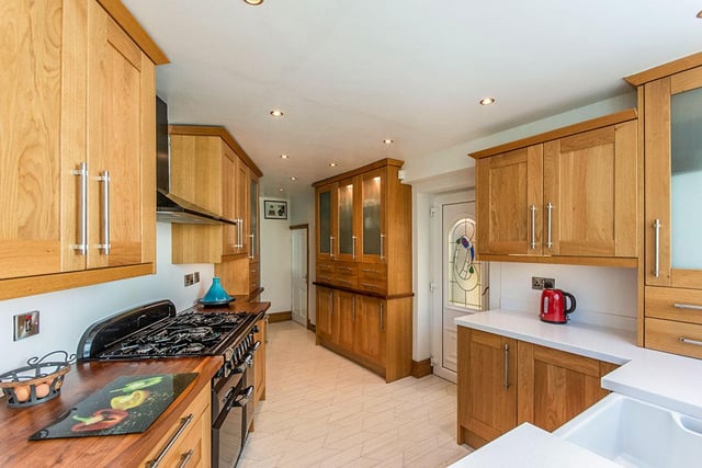 This uniquely shaped kitchen has plenty of cupboard space and access to the Orangery.