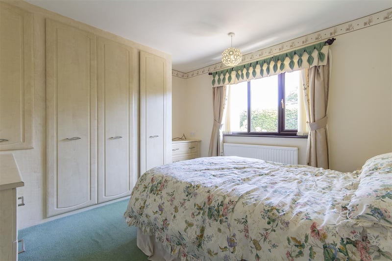 Bedroom one is described as a "good-sized, rear-facing, double bedroom having a range of fitted wardrobes and drawer units".