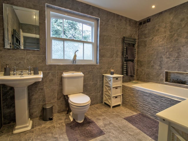 Fully tiled with underfloor heating, comprising of bath, WC, wash basin, wall mounted towel rail and shaver points.