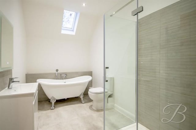 Fitted with a freestanding bath, separate shower cubicle, and wash basin set into vanity unit.