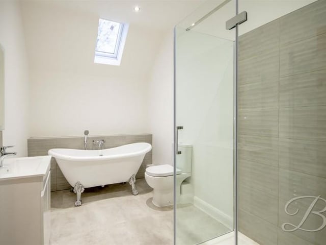 Fitted with a freestanding bath, separate shower cubicle, and wash basin set into vanity unit.