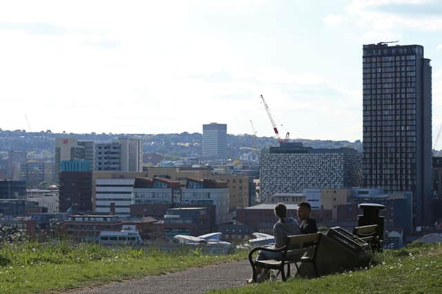 A man and woman sit on a bench and enjoy the sunshine in Sheffield (Photo by LINDSEY PARNABY/AFP via Getty Images)
