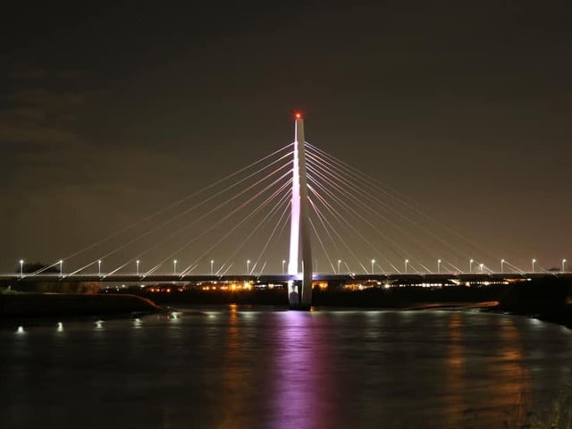 A peaceful view of the Northern Spire bridge over the river.