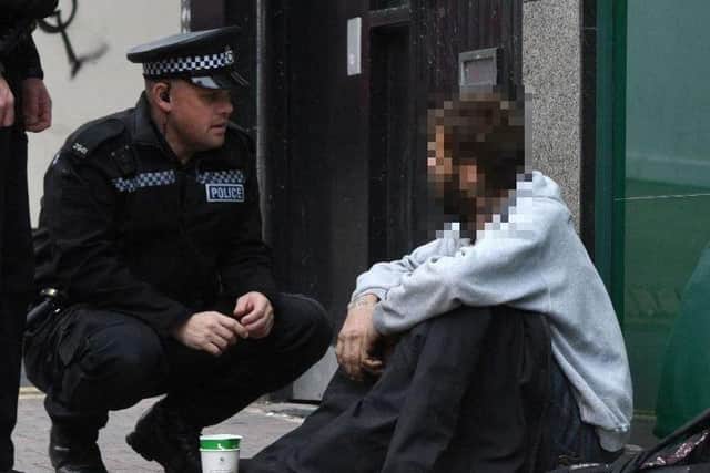A police officer talking to a beggar in Sheffield city centre.
