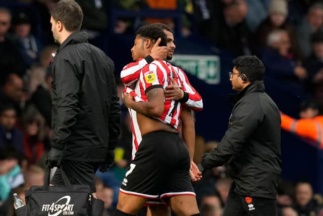 lliman Ndiaye gives Sheffield United teammate Rhian Brewster a hug as he goes off injured at West Brom: Andrew Yates / Sportimage