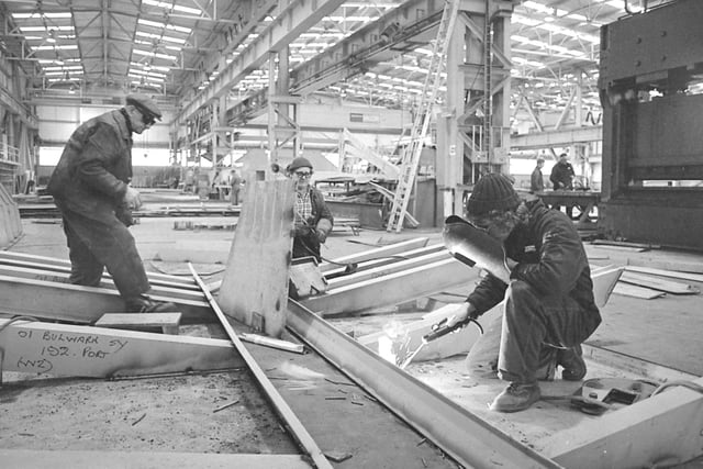 Inside Sunderland Shipbuilders, Ltd, new £11 million undercover shipyard complex at Pallion. At work in the assembly shop are, left to right, welders Steve Eade and Thomas Harrison, and plater Bob Jobling.
