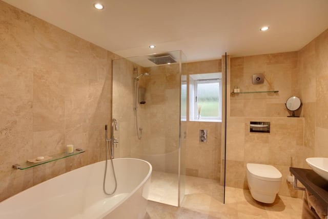 The family bathroom is fully tiled with underfloor heating - it has a freestanding bath and a separate walk-in shower enclosure with a fitted 'rainfall' shower head.