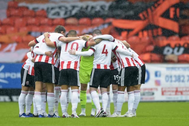Sheffield United players take part in a pre-match huddle ahead of their friendly with Dundee United at Tannadice