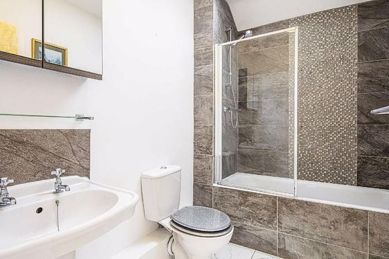 This is the family bathroom, in which there is a white suite with a shower over the bath.