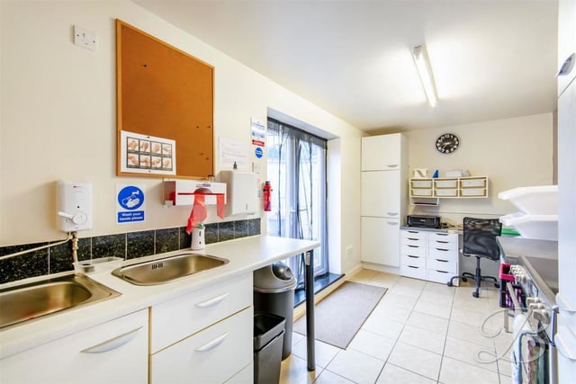 This is the workshop's kitchen, which could also be used as an office. It comes complete with cabinets, work surface, inset sink, tiled flooring, larder unit, fitted work station, cupboard and patio doors leading outside.