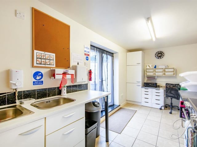 This is the workshop's kitchen, which could also be used as an office. It comes complete with cabinets, work surface, inset sink, tiled flooring, larder unit, fitted work station, cupboard and patio doors leading outside.