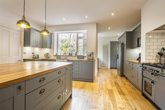 The L-shaped breakfast kitchen has a Belfast sink and contemporary work surfaces.