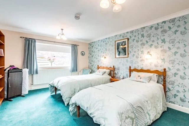 This spacious bedroom is one of five in the property