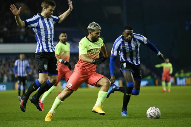 Sergio Aguero of Manchester City is challenged by Julian Borner and Dominic Iorfa of Sheffield Wednesday during the FA Cup Fifth Round match  (Photo by Alex Livesey/Getty Images)