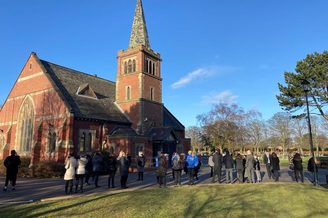 People gathered outside the crematorium before Tuesday's service.