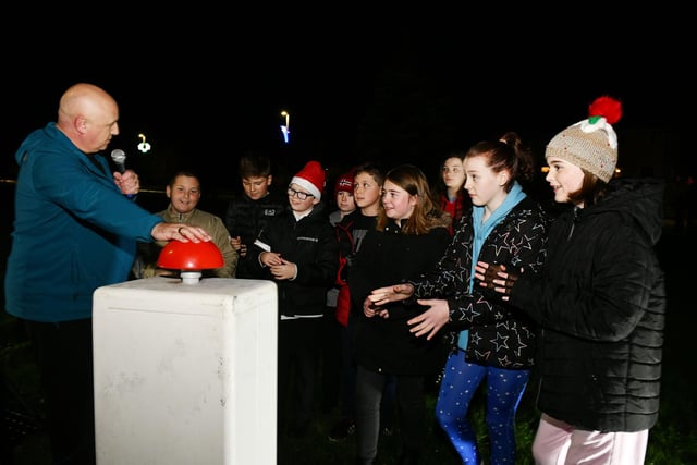 Local resident and singer Dougie Smith and some Carronshore Primary 7 pupils switch on the lights.