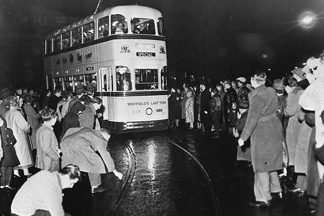 People lay coins on the tram tracks for souvenirs as the last tram makes its way through the streets of Sheffield in 1960